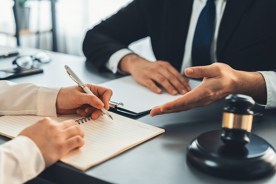 Lawyer colleagues or legal team working or drafting legal document at law firm office desk. Gavel hammer for righteous and equality judgment by lawmaker and attorney. Equilibrium